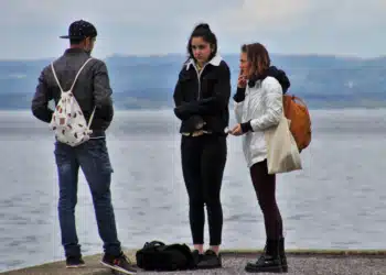 Den gode samtale - 2 kvinder og 1 mand snakker på strand. Den ene kvinder ryger en cigaret