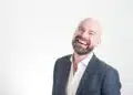 Faglig ledelse - den professionelle mand i jakkesæt og smilende på hvid baggrund