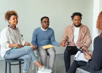 Psykisk arbejsmiljø - 3 mennesker i terapi holder hinanden i hænderne