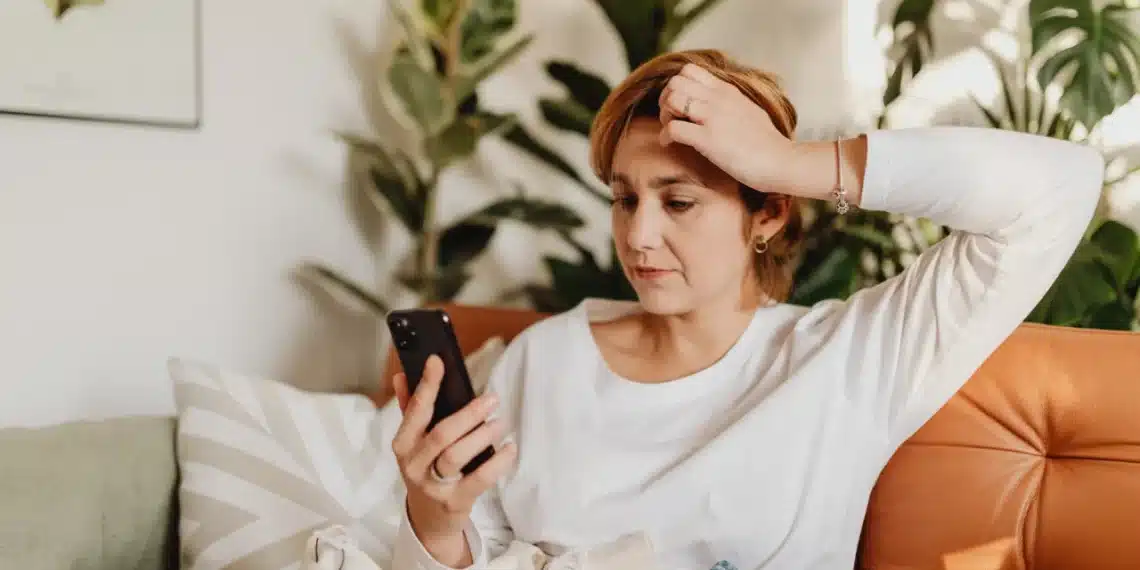 dårlig ledelse skaber rod og kaos - opgivende kvinde i sofa kigger på sin telefon