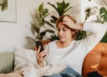 dårlig ledelse skaber rod og kaos - opgivende kvinde i sofa kigger på sin telefon