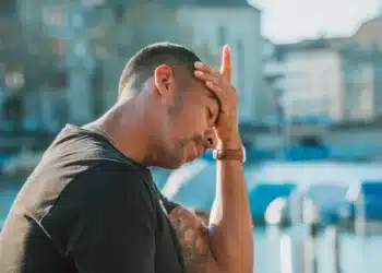 stress på arbejdspladsen - mand hviler hovedet på venstre hånd