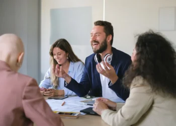 God ledelse - her et godt team af mennesker ved et skrivebord - mand griner højt