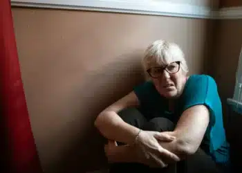 Hvad er gaslighting kvinde sidder ensom i lille rum og ser bange ud