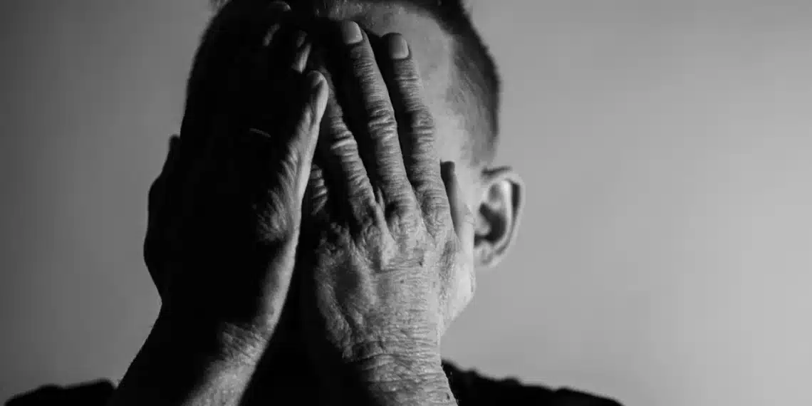 I tvivl som leder - mand holder hænderne oppe foran ansigtet i dyb tvivl