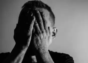 I tvivl som leder - mand holder hænderne oppe foran ansigtet i dyb tvivl