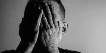 I tvivl som leder - mand holder hænderne oppe foran ansigtet i dyb tvivl