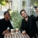To mænd sidder på cafe og drikker kaffe og tager en selfie som udtryk for den gode samtale