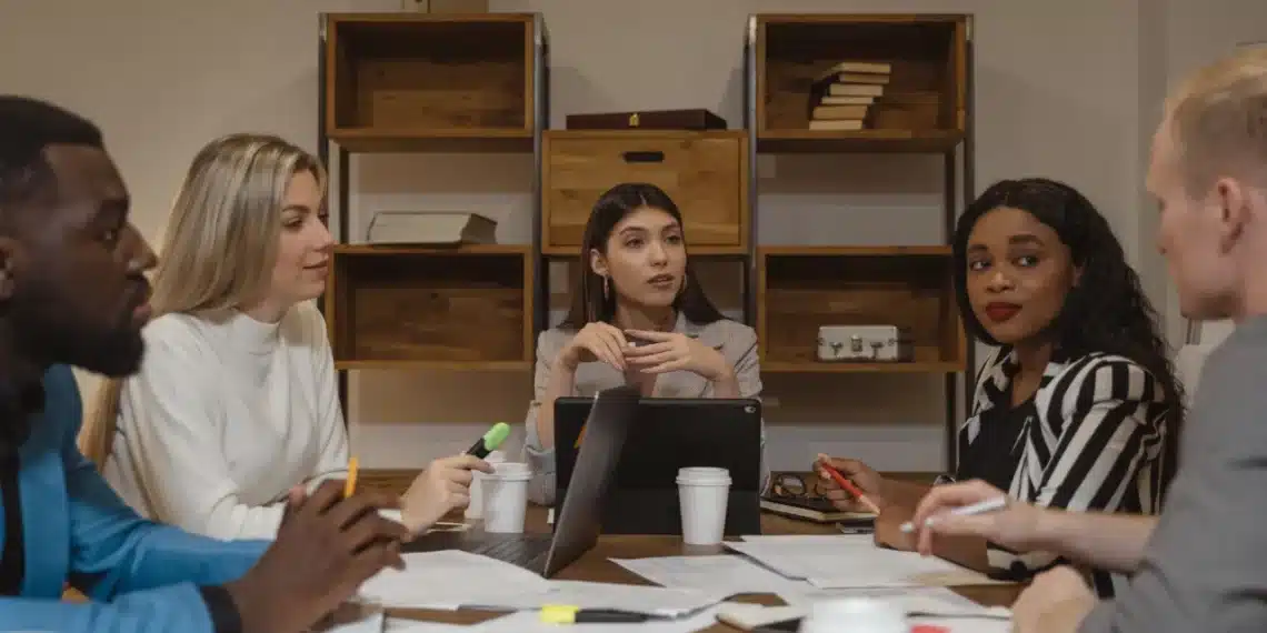 ledelse af ledere - 3 kvindelige ledere sidder ved rundt skrivebord og samtaler