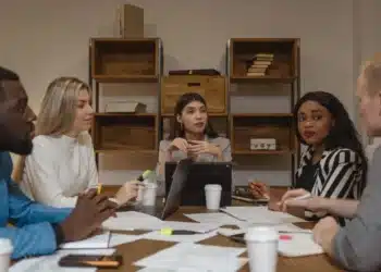 ledelse af ledere - 3 kvindelige ledere sidder ved rundt skrivebord og samtaler