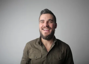 mand står afslappet og smiler som udtryk for et godt psykisk arbejdsmiljø (arbejdsmiljoe)