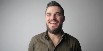 mand står afslappet og smiler som udtryk for et godt psykisk arbejdsmiljø (arbejdsmiljoe)