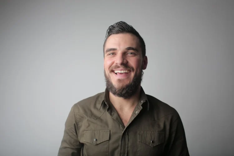 mand står afslappet og smiler som udtryk for et godt psykisk arbejdsmiljø (arbejdsmiljoe)