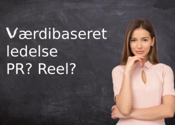 værdibaseret ledelse står på en tavle med lærerinden i forgrunden.