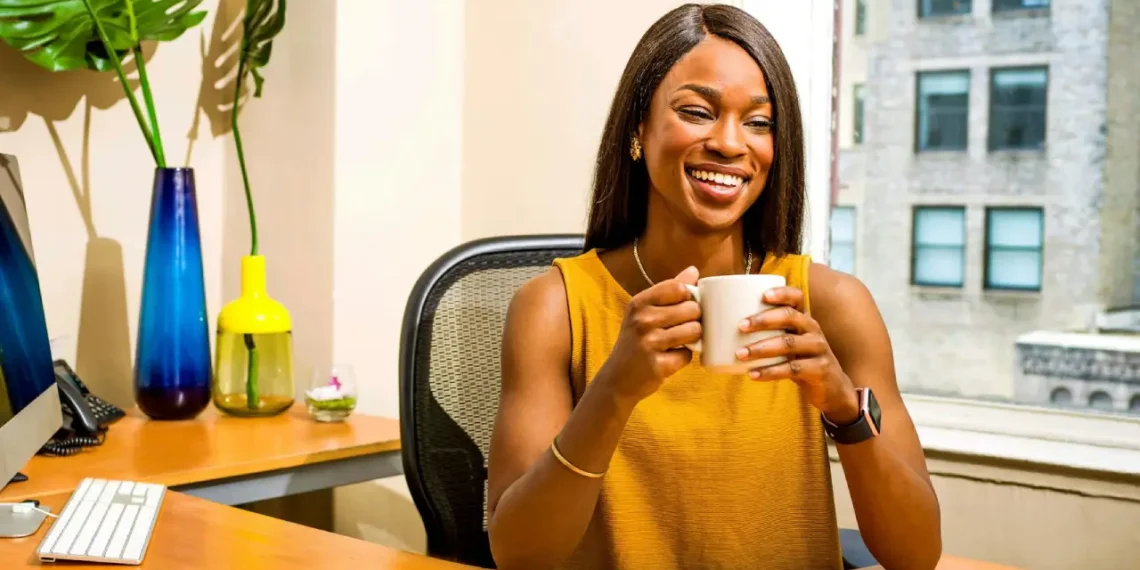 Hvad er god ledelse - tilfreds kvinde bag sit skrivebord