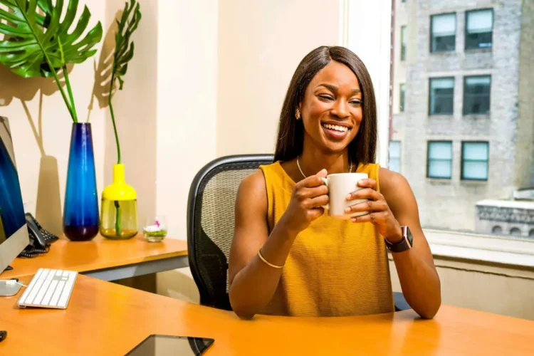 Hvad er god ledelse - tilfreds kvinde bag sit skrivebord