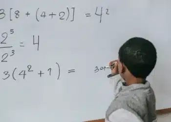 Lineær logik vs socialkonstruktionisme - dreng står ved tavle om foretager udregninger af potenser (matematik)