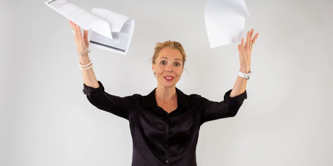 Stresssymptomer kvinder kaster løse papirer op i luften af opgivelse