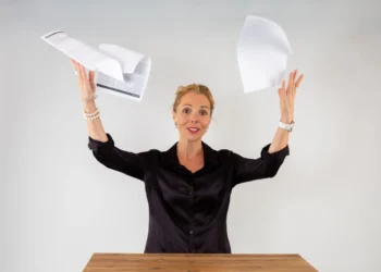 Stresssymptomer kvinder kaster løse papirer op i luften af opgivelse