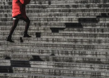 Konflikttrappen kvinde i rød jakke går op af trapper