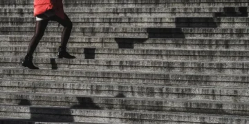 Konflikttrappen kvinde i rød jakke går op af trapper