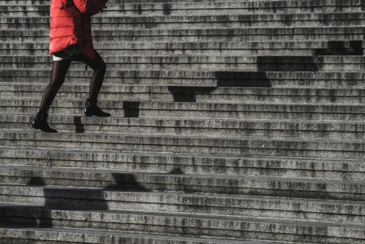 Konflikttrappen kvinde i rød jakke går op af trapper