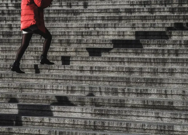 Konflikttrappen kvinde i rød jakke går op af trapper