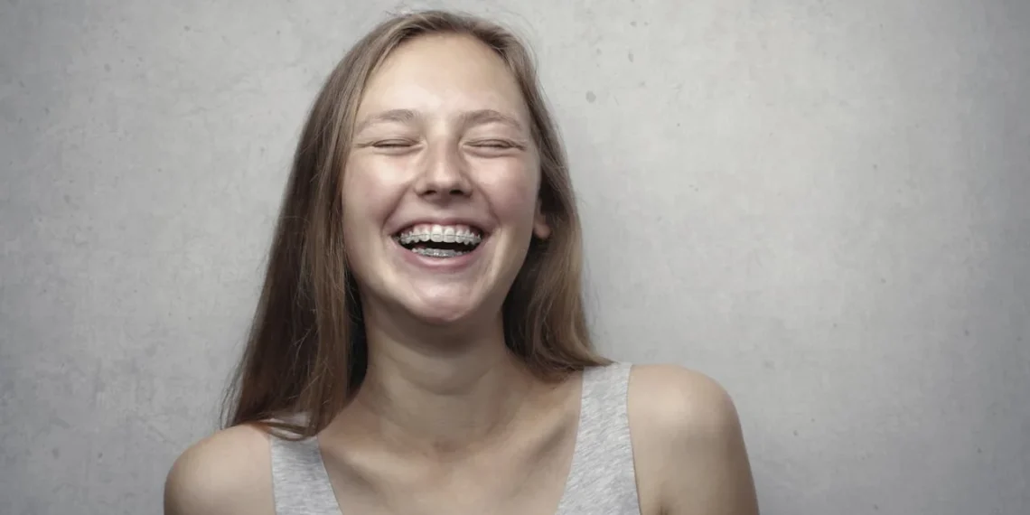 Pige smiler stort i McClellands behovsteori med lukkede øjne.