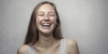 Pige smiler stort i McClellands behovsteori med lukkede øjne.