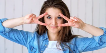 Køn piger laver Uma Turman med begge hænder som tegn på ambivert