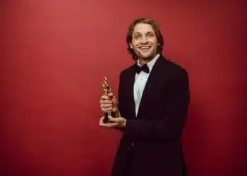 belønningsteori mand med præmie smiler med rødt bagtæppe