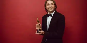 belønningsteori mand med præmie smiler med rødt bagtæppe