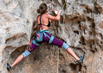 Motivation kvinde klatrer alene op bjergside