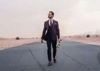 Tegn på man sige op - mand i jakkesæt går mod kameraet med skateboard i hånden