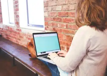 sor-modellen i anvendelse af kvinde siddende på bænk med computer