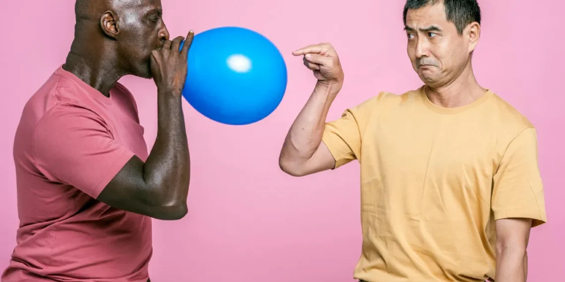 Mand blæser ballon op mens anden mand peger på den som udtryk for tryghedscirklen