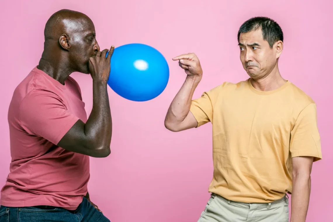 Mand blæser ballon op mens anden mand peger på den som udtryk for tryghedscirklen