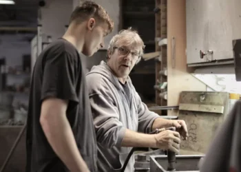 Mentoring mand står og viser lærling teknik på drejebænk