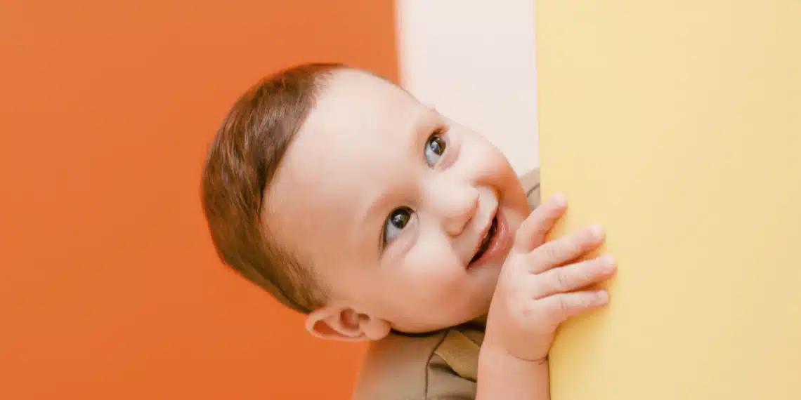 pyt-knappen - barn kigger glad rundt om hjørnet