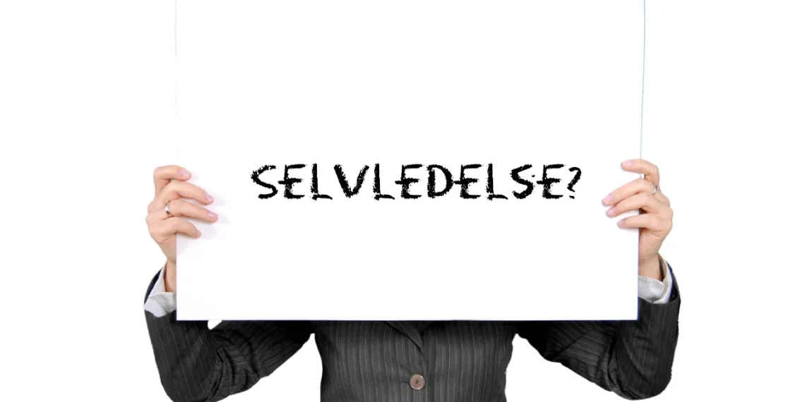 Selvledelse skrevet med sort kridt på whiteboard holdt af et menneske