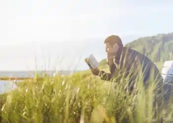 dunning-kruger-effekten mand sidder og læser i en bog på bænk i klitterne