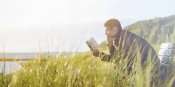 dunning-kruger-effekten mand sidder og læser i en bog på bænk i klitterne