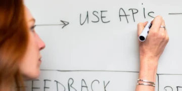 Kvinde arbejder agilt på tavle som udtryk for agilitet