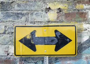 Gult skilt med sort pil i begge retninger som i lotteriledelse