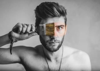 Krav til leder - sort/hvid billede af mand som maler sit ansigt med pensel