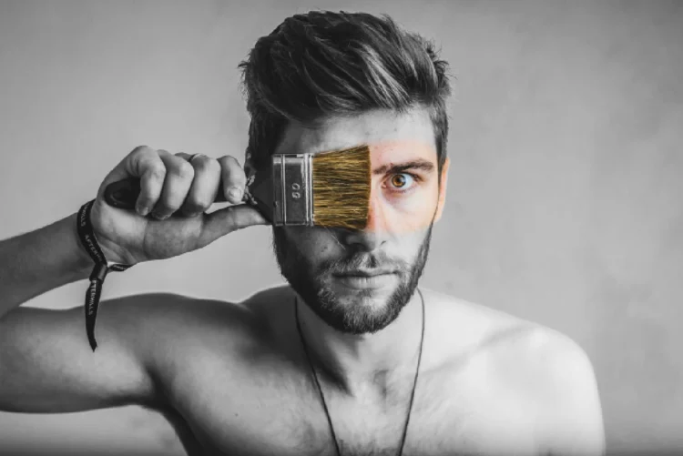 Krav til leder - sort/hvid billede af mand som maler sit ansigt med pensel