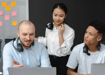 3 medarbejdere bag computer som udtryk for kommunikation i ledelse