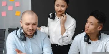 3 medarbejdere bag computer som udtryk for kommunikation i ledelse