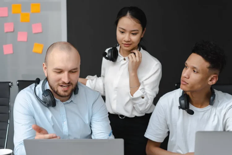 3 medarbejdere bag computer som udtryk for kommunikation i ledelse