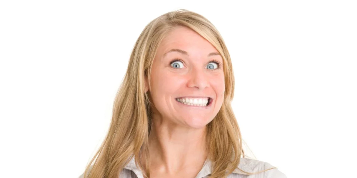 Happy firing - kvinde smiler falskt til kameraet